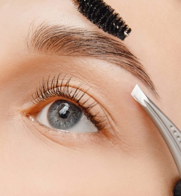 Procedimiento de depilación de cejas con pinzas realizado por una profesional en el centro Rocío Martín Micropigmentación y Estética en Madrid; la técnica permite una definición precisa de la forma de las cejas respetando la piel sensible del rostro y asegurando un resultado limpio, uniforme y duradero.