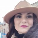 Clienta con sombrero beige y labios fucsia posando al aire libre, imagen para la sección de testimonios de Rocío Martín Micropigmentación y Estética